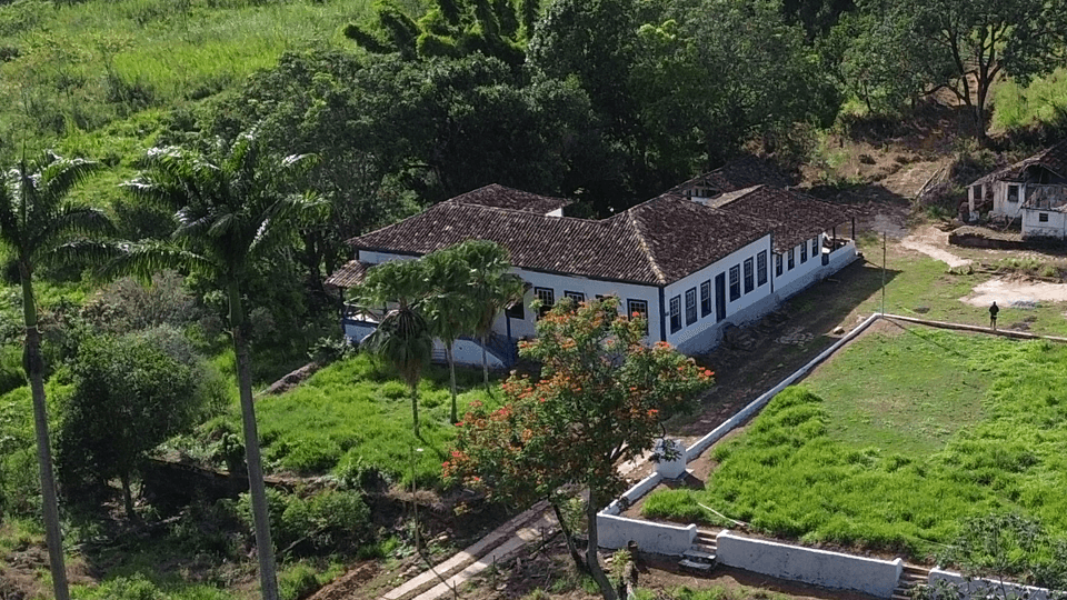 Vista aérea da sede da Fazenda Santa Clara, com o casarão colonial de telhado de barro e os jardins ao redor
